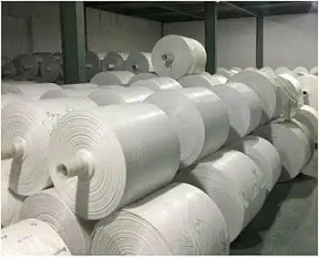 A warehouse stacked with rolls of white PP woven fabric