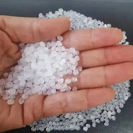 A handful of PP granules held over a pile